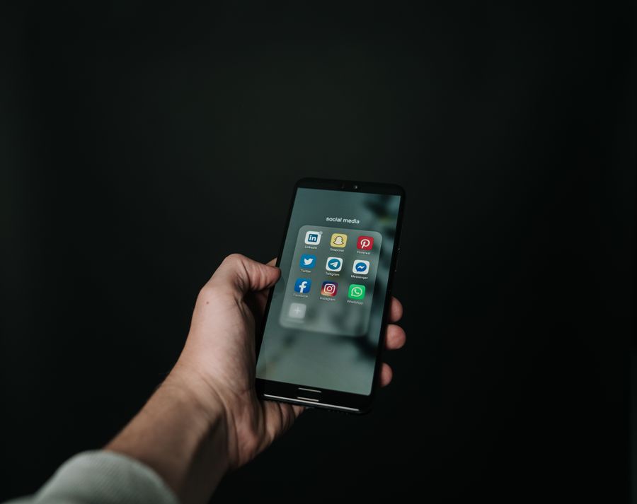 Tangan memegang ponsel pintar menampilkan aplikasi