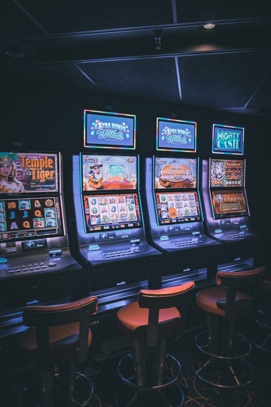 Barisan mesin slot menyala warna-warni di dalam kasino